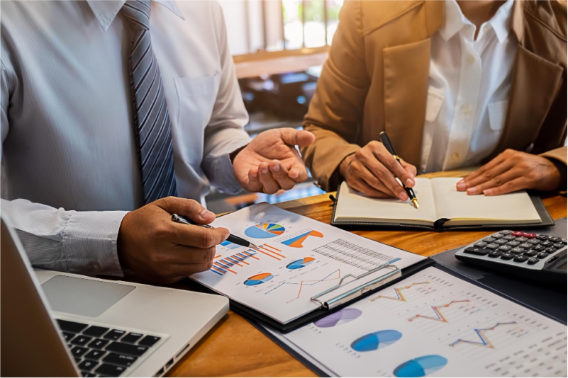 Profissionais de administração analisando gráficos e relatórios